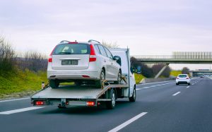 Tow truck with car on warranty on road